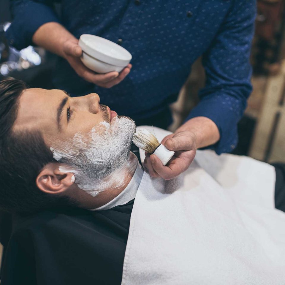barber-applying-foam-before-shaving-of-customer-in-2022-12-16-17-03-17-utc.jpg